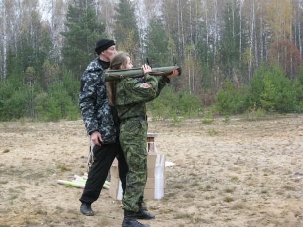 Російський військовий вчить дівчинку користуватися зброєю. Фото: ЖЖ.