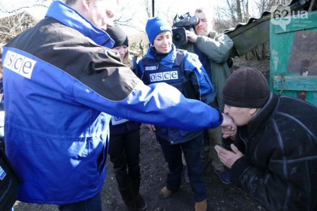 Мешканка Зайцевого цілує руку члену місії ОБСЄ на Донбасі. Фото:http://www.62.ua/
