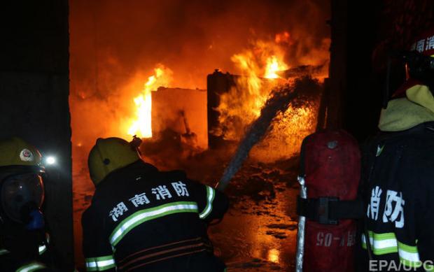Охоплена пожежею будівля на місці катастрофи китайського винищувача. Фото: EPA \ UPG