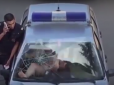 Напівгола росіянка ногами видавила лобове скло поліцейської машини (відео)