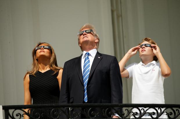 Дональд Трамп з дружиною та сином спостерігають за сонячним затемненням. Фото:https://www.reuters.com/