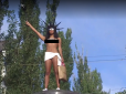 Кидалася цукерками: У Києві активістка Femen з оголеними грудьми забралася на постамент (відео 18+)