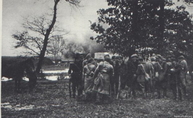 Бійці польської Арміїі Крайової на фоні палаючого села Сагринь.