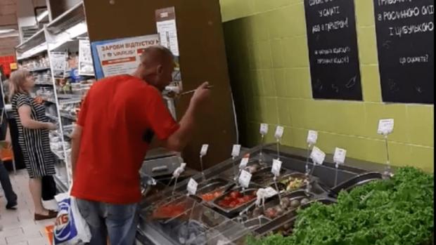 Чоловік вирішив поїсти прямо на очах інших покупців. Фото: скріншот з відео.