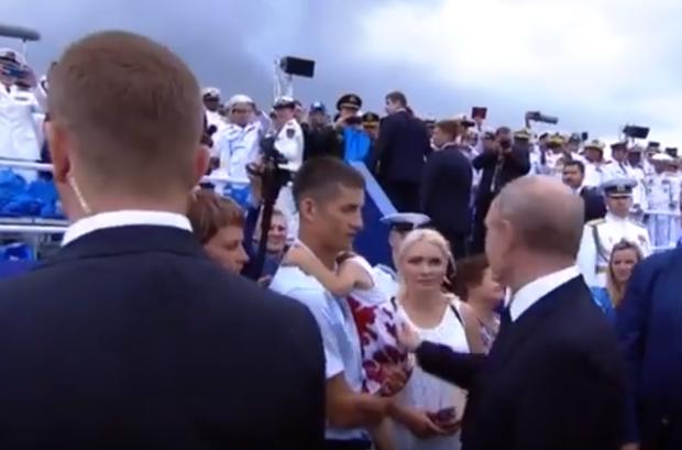 Путін ляскає дитину по попі. Фото: скріншот з відео.