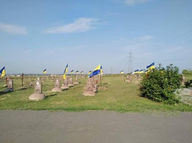 У Дніпрі комунальники зняли прапори з могил. Фото: Фейсбук.