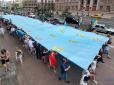 День кримськотатарського прапора: Центром Києва прямує хода з величезним полотнищем, учасники скандують: 
