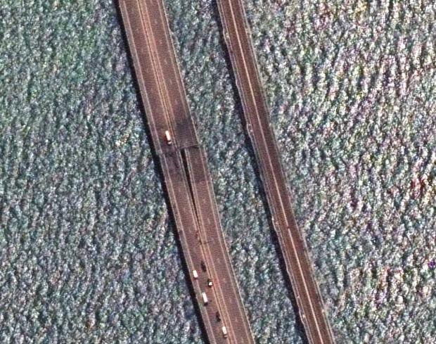 Супутниковий знімок показує, що обидва прольоти автомобільного мосту зірвані з опор, той що ближче до залізничного мосту помітніше