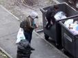 Місцеві вже звикли до цього видовища: У Києві мати закидає хлопчика до сміттєвих баків, щоб той шукав пляшки (фото)