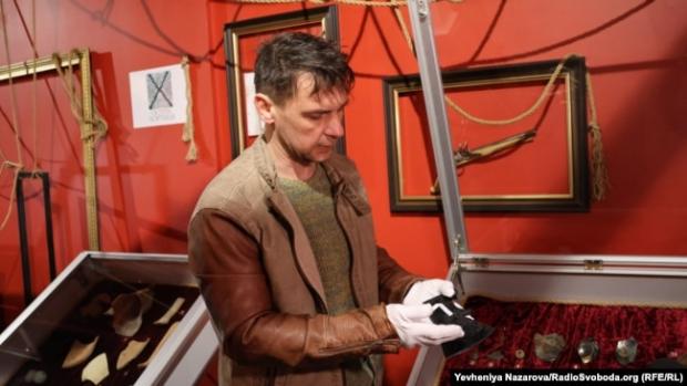 Андрій Денисенко, реставратор Національного заповідника «Хортиця», показує залізний фрагмент теслярської сокири 18 ст.