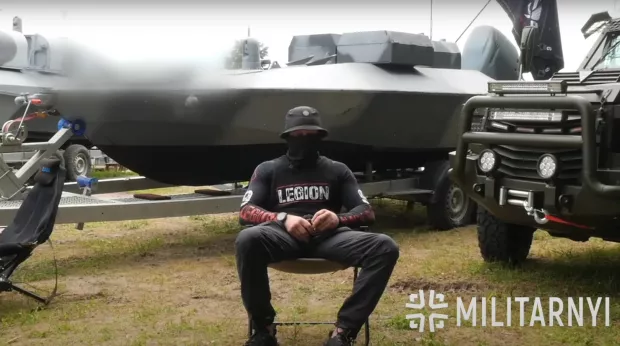 Спецпризначенець ГУР МО на фоні морського дрона "Катран". Червень 2025. Україна. Джерело: "Мілітарний"
