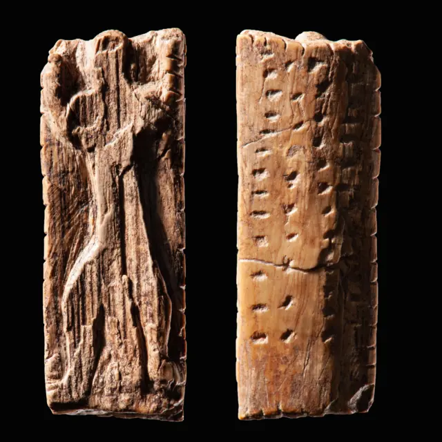 Невелика пластина зі слонової кістки з антропоморфною фігурою та кількома рядами зарубок і крапок. Вид спереду і ззаду тієї самої пластини
